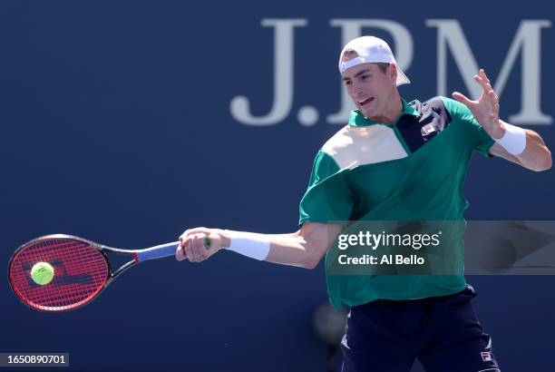 John Isner of the United States returns a serve against Michael Mmoh of the United States during their Men's Singles Second Round match on Day Four...