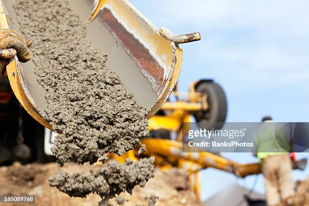 construction worker guiding cement mixer truck trough - pouring stock pictures, royalty-free photos & images