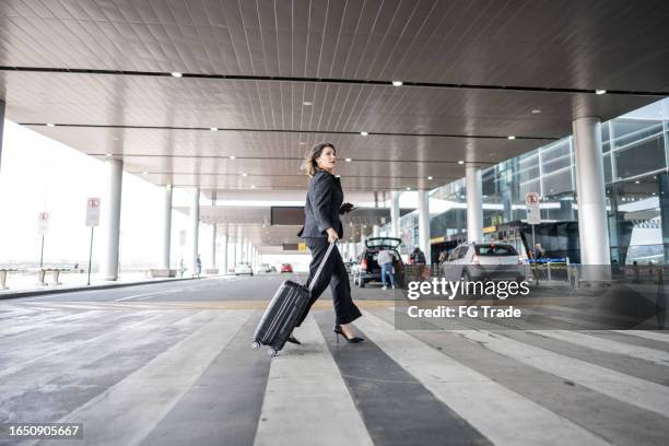 businesswoman walking at the airport - priority boarding stock pictures, royalty-free photos & images