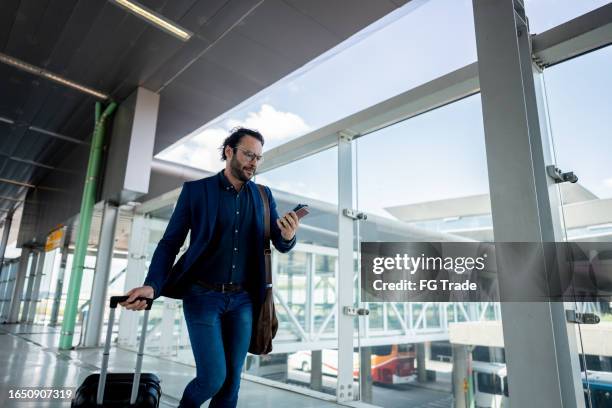 businessman running while use phone at the airport - man reading card stock pictures, royalty-free photos & images