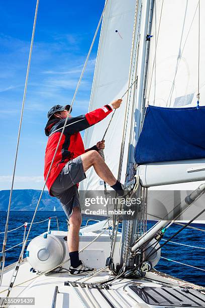 in barca, skipper è issare la mainsail - issare foto e immagini stock