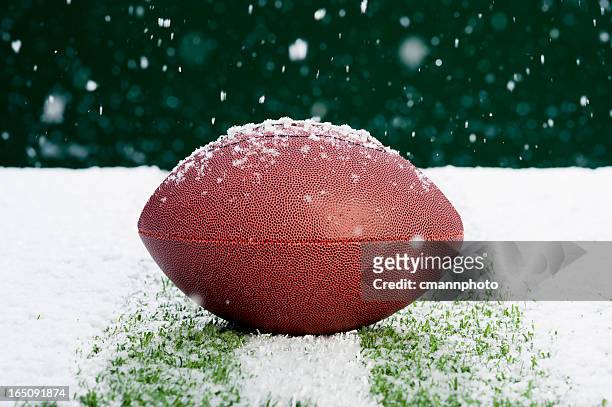 american football on snow covered grass - snow on grass stock pictures, royalty-free photos & images