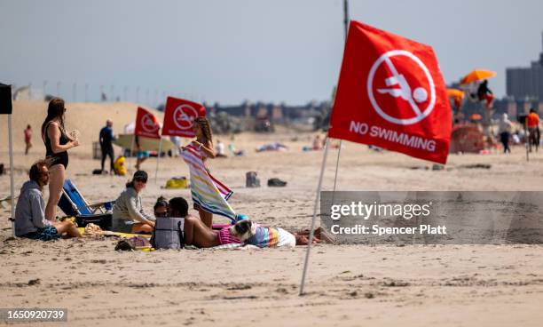 Flags warn that the beach is closed to swimmers at Rockaway Beach in New York as high surf from Hurricane Franklin delivers strong rip tides and...