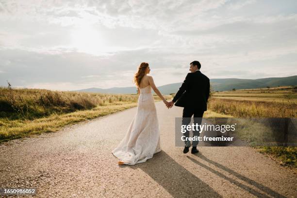 hand in hand among summer beauty - bride and groom back stock pictures, royalty-free photos & images