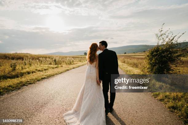 hand in hand among summer beauty - bride and groom back stock pictures, royalty-free photos & images