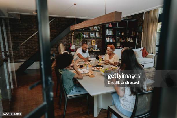 multigenerational family having lunch at the table - big family dinner stock pictures, royalty-free photos & images