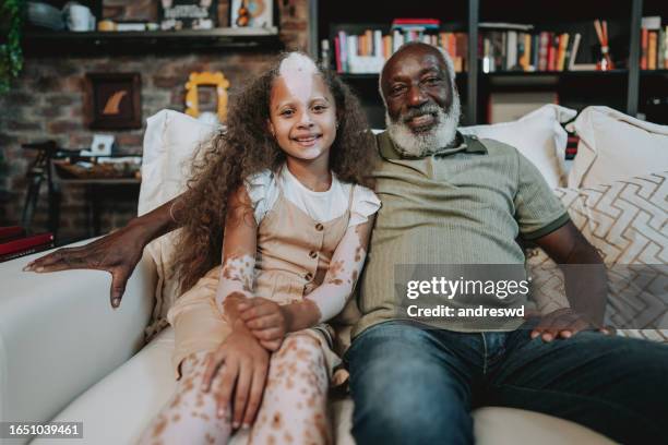 portrait grand-père avec petite-fille atteinte de vitiligo - réunion de famille photos et images de collection