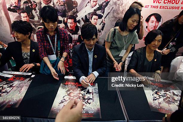 Cast members Wu Zhun, Vic Chou and Ekin Cheng of "Saving General Yang" sign autographs for fans at a meet and greet event in Square 2 on March 30,...