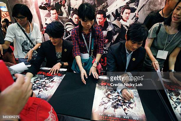 Cast members Vic Chou and Wu Zhun of "Saving General Yang" sign autographs for fans at a meet and greet event in Square 2 on March 30, 2013 in...