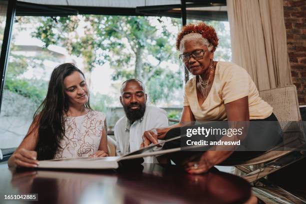 family viewing wedding photo album - old wedding album book stock pictures, royalty-free photos & images