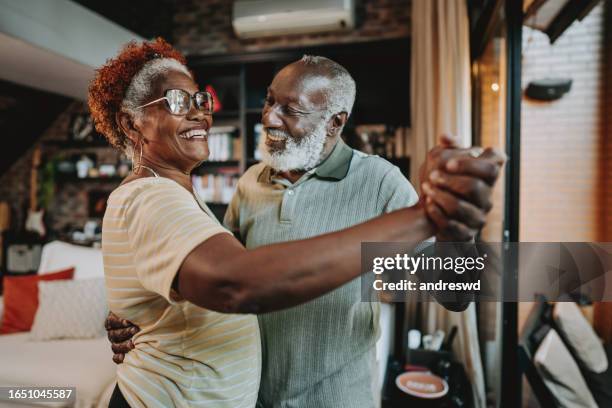 senior couple dancing at home - couple dancing at home stockfoto's en -beelden