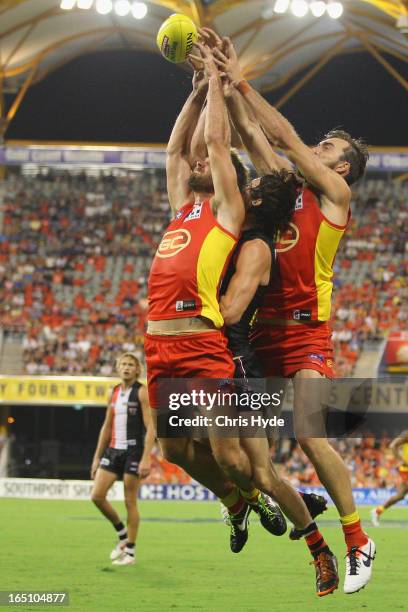 Jared Brennan and Charlie Dixon of the Suns and Dylan Roberton of the Saints attempt a mark during the round one AFL match between the Gold Coast...