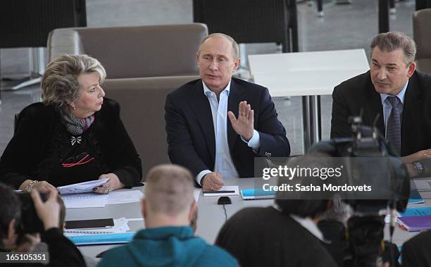 Russian President Vladimir Putin speaks as Figure Scating coach Tatiana Tarasova and former goaltender for the Soviet Union's national ice hockey...