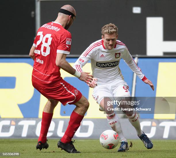 Andre Schuerrle of Leverkusen tackles Martin Latka of Duesseldorf during the Bundesliga match between Fortuna Duesseldorf and Bayer Leverkusen at...