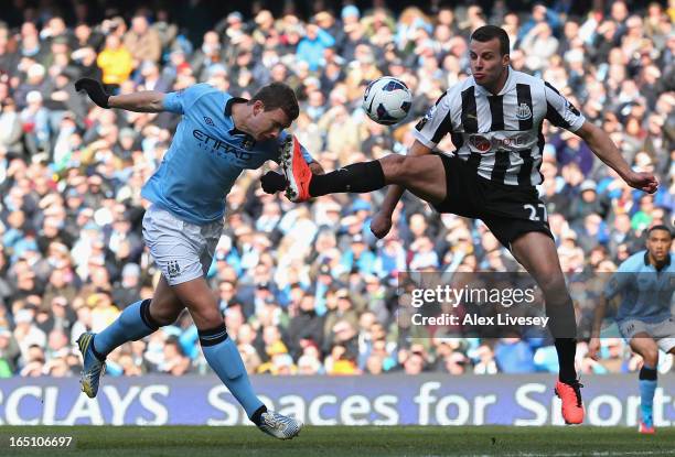 Steven Taylor of Newcastle United tries to block the header of Edin Dzeko of Manchester City during the Barclays Premier League match between...