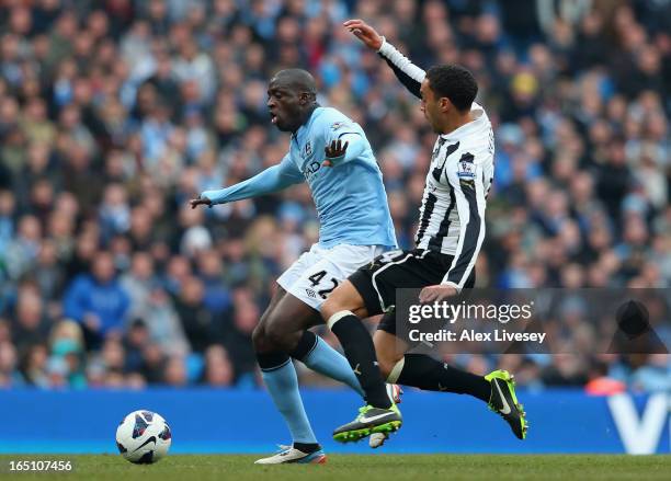 James Perch of Newcastle United challenges Yaya Toure of Manchester City during the Barclays Premier League match between Manchester City and...