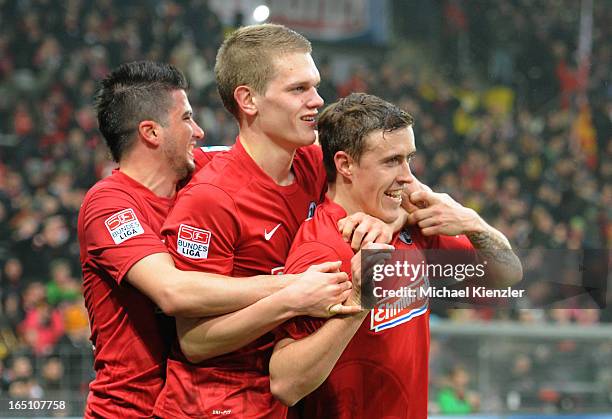 Max Kruse of Freiburg celebrates his second goal with Marco Terrazzino and Matthias Ginter during the Bundesliga match between SC Freiburg and VfL...