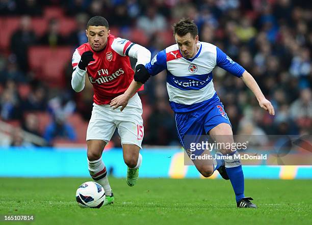 Alex Oxlade-Chamberlain of Arsenal battles with Nicky Shorey of Reading during the Barclays Premier League match between Arsenal and Reading at...