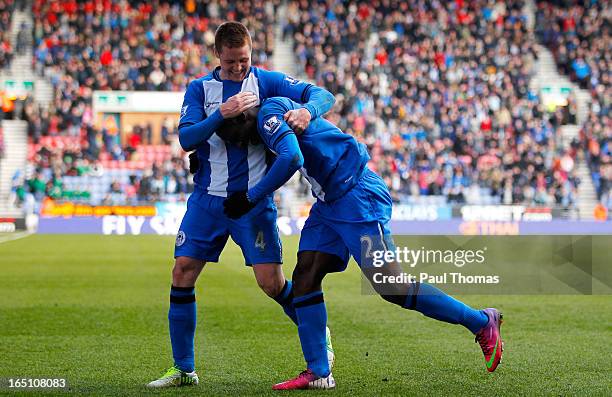 Arouna Kone of Wigan celebrates his goal with team mate James McCarthy during the Premier League match between Wigan Athletic and Norwich City at the...