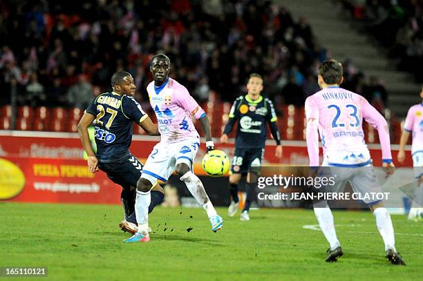 Reims' French defender Christopher Glombard vies with Evian's Ghanaian midfielder Mohammed Rabiu during their French L1 football match Evian vs Reims...