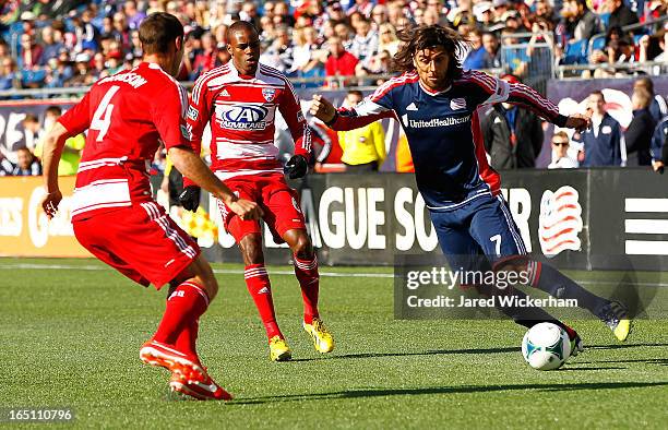 Juan Toja of New England Revolution carries the ball in front of Andrew Jacobson of FC Dallas during the game at Gillette Stadium on March 30, 2013...