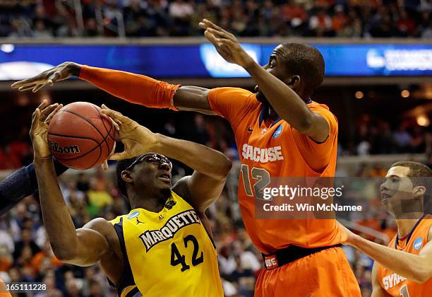 Chris Otule of the Marquette Golden Eagles makes draws contact against Baye Keita of the Syracuse Orange during the East Regional Round Final of the...