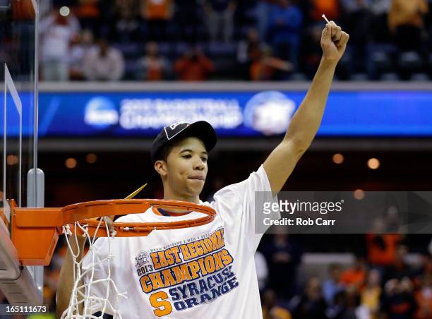 Michael Carter-Williams of the Syracuse Orange cuts down the net after defeating the Marquette Golden Eagles to win the East Regional Round Final of...
