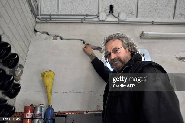 Netherland's Elze Schollema shows on March 12, 2013 a crack in his garage wall in Usquert, some 25km from Groningen, caused by an earthquake in...