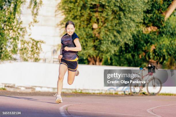 a pre-teen girl is running at the school stadium - pre adolescent child bildbanksfoton och bilder