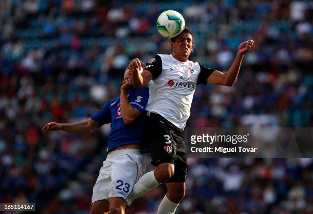 Nicolas Bertolo of Cruz Azul fights for the ball with Luis Ramos of Atlas during a match between Cruz Azul and Atlas as part of the Clausura 2013 at...