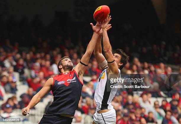 Angus Monfries of the Power and Jimmy Toumpas of the Demons compete for the ball during the round one AFL match between the Melbourne Demons and Port...