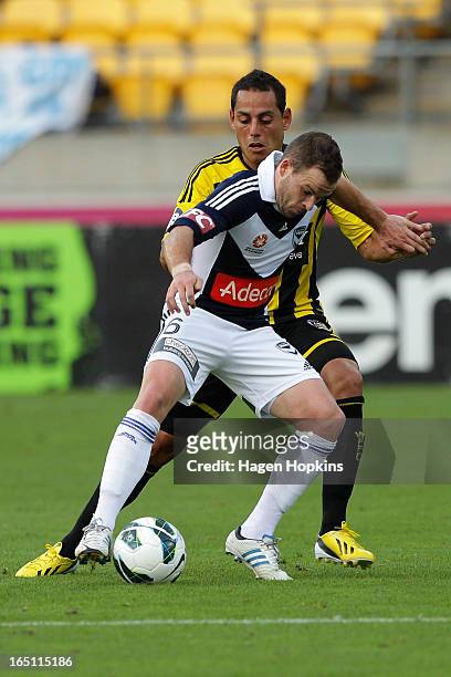 Leigh Broxham of the Victory holds off the defence of Leo Bertos of the Phoenix during the round 27 A-League match between the Wellington Phoenix the...
