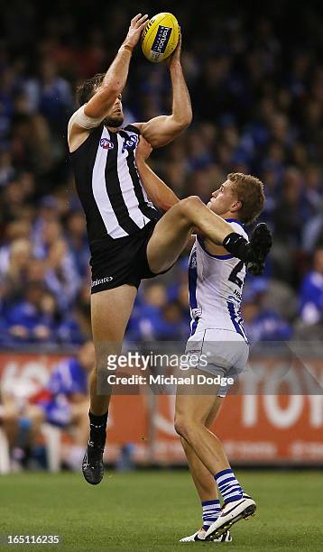 Nathan Brown of the Magpies marks the ball against Kieran Harper of the Kangaroos during the round one AFL match between the North Melbourne...