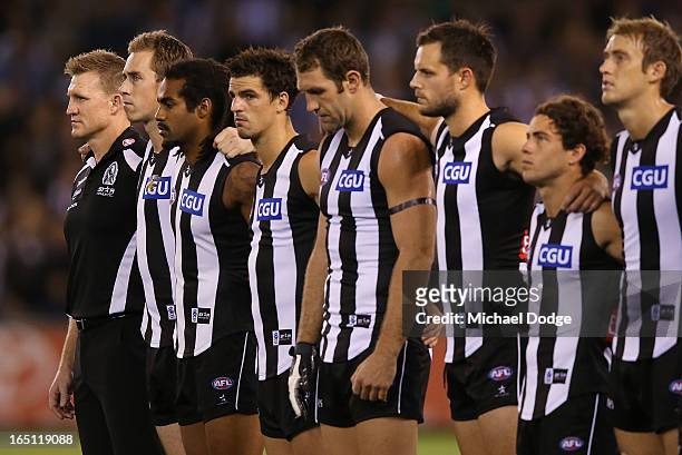 Collingwood Magpies coach Nathan Buckey and players line up for the National Anthem during the round one AFL match between the North Melbourne...