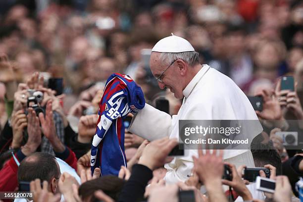 Pope Francis is given a San Lorenzo's shirt, the Buenos Aires football team as he greets the faithful prior to his first 'Urbi et Orbi' blessing from...