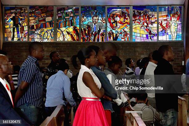 Former South African President Nelson Mandela and the struggle against apartheid are depicted in a stained glass window as congregants pray during...