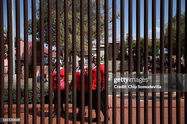 Tourists are seen through the fence surrounding the Mandela House and Museum on historic Vilakazi Street in Soweto March 31, 2013 in Johannesburg,...