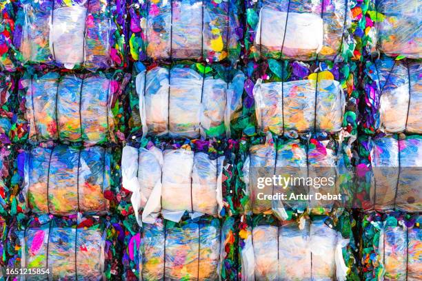 composition of a colorful piles of crushed plastic bales stacking in a recycling plant. - circulaire economie stockfoto's en -beelden