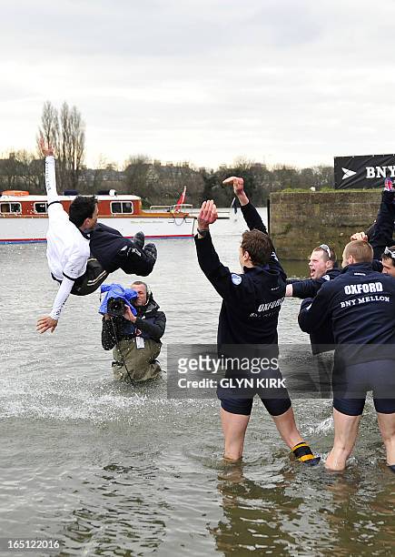 Oxford rowers celebrate by throwing their US-Colombian cox Oskar Zorrilla into the river after Oxford's victory over Cambridge in the 159th annual...