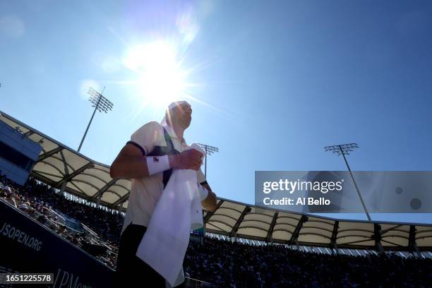 John Isner of the United States wipes his face against Michael Mmoh of the United States during their Men's Singles Second Round match on Day Four of...