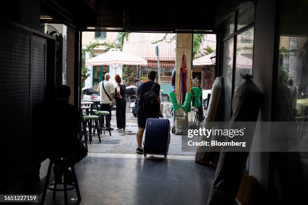 Man pulls a suitcase as he leaves a hotel in Athens, Greece, on Thursday, Sept. 7, 2023. DBRS Morningstar is set to update its assessment on Friday,...