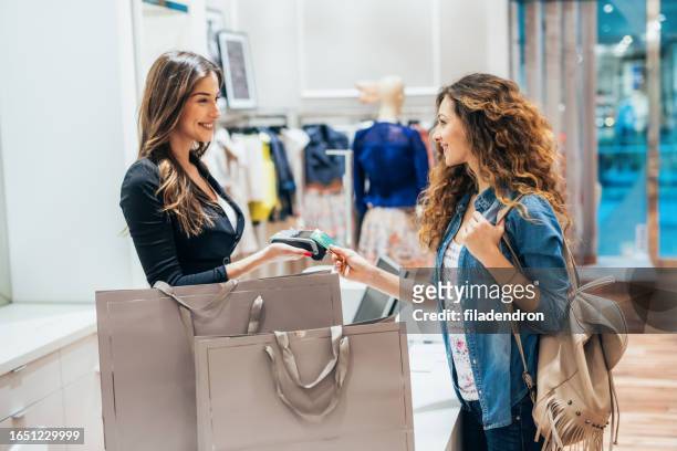 paying via credit card at a clothing store - charging stock pictures, royalty-free photos & images