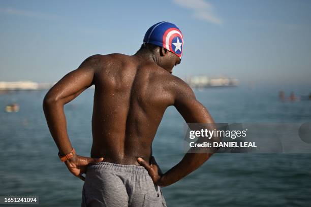 Beachgoer prepares to leap into the sea at Brighton, on the south coast of England on September 7 as the late summer heatwave continues.