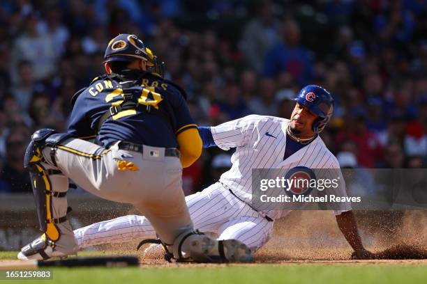 William Contreras of the Milwaukee Brewers tags out Christopher Morel of the Chicago Cubs at home plate during the eighth inning at Wrigley Field on...