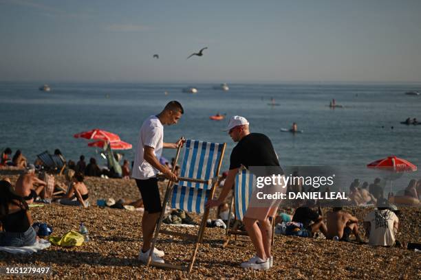 Beachgoers arrange deckchairs on the beach at Brighton, on the south coast of England on September 7 as the late summer heatwave continues.