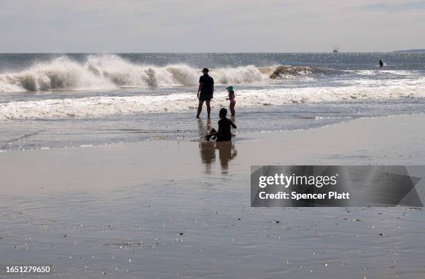 People enjoy a day at Rockaway Beach in New York as high surf from Hurricane Franklin delivers strong rip tides and large waves to most of the...