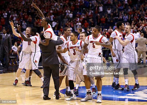 Russ Smith of the Louisville Cardinals is held up by assistant coach Kevin Keatts as they celebrate with teammates after they won 85-63 against the...