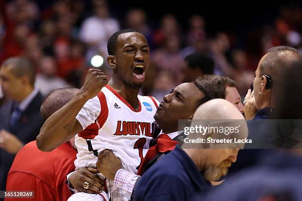 Russ Smith of the Louisville Cardinals is held up by assistant coach Kevin Keatts as they celebrate with teammates after they won 85-63 against the...