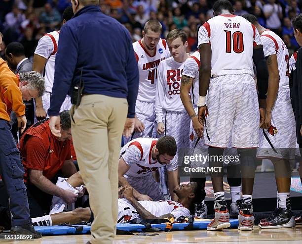 Louisville teammates gather around teammate Louisville guard Kevin Ware after he broke his right leg in first half action in the NCAA regional final...