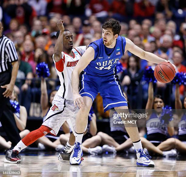 Louisville guard Russ Smith tries to stop Duke forward Ryan Kelly in second half action in the NCAA regional final game on Sunday, March 31 in...